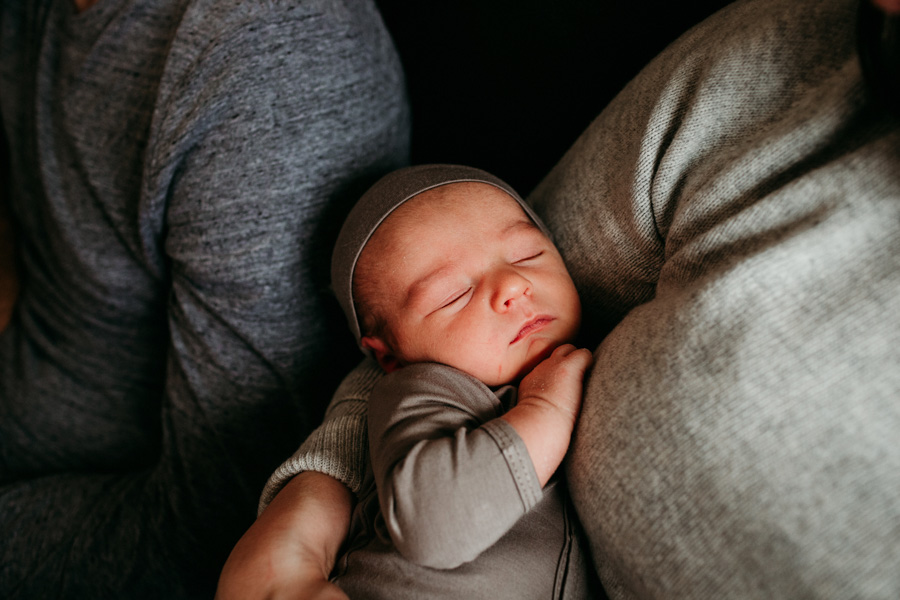 Closeup of newborn sleeping between his parents